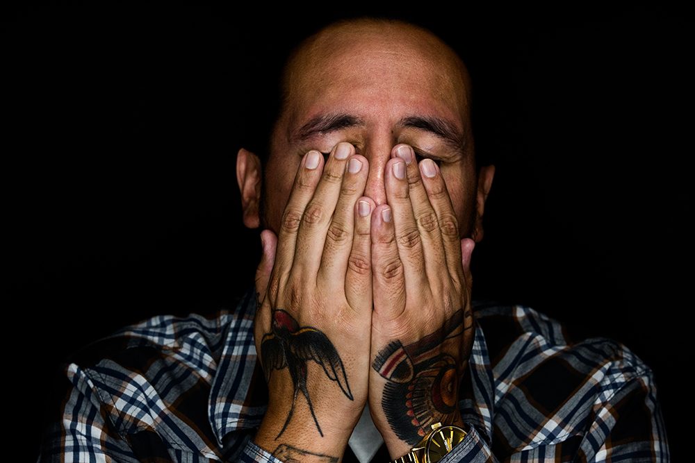 Man reflecting quietly, head in hands