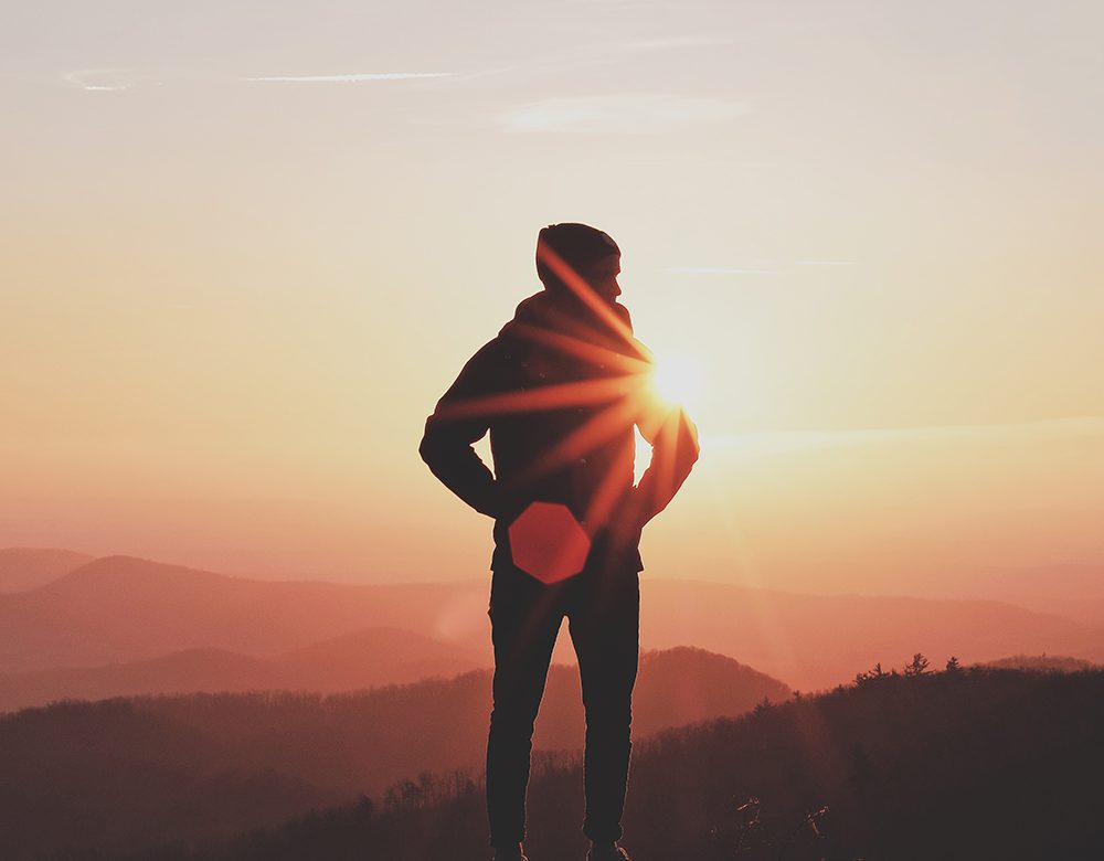 Man at peace on a trail at sunrise